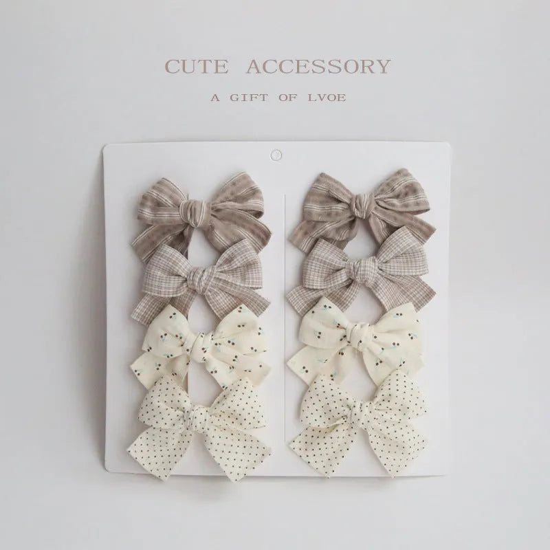 Children's dovetail bow hairclips in eight colour patterns including grid dots and floral designs