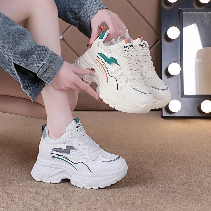 Women's white and beige dad shoes with cross shoulder straps and lace-up front, showing round toe.