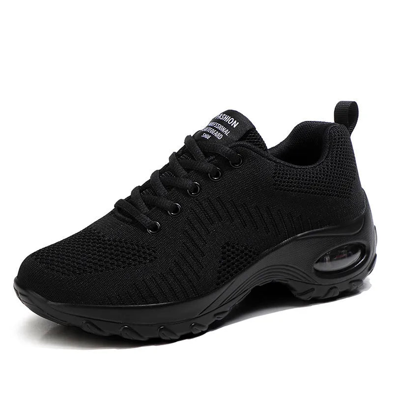 Women's black mesh sneakers with lace-up front and round toe, showing mid-heel height