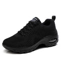 Women's black mesh sneakers with lace-up front and round toe, showing mid-heel height