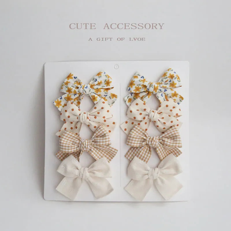 Children's dovetail bow hairclips in eight colour patterns including grid dots and floral designs