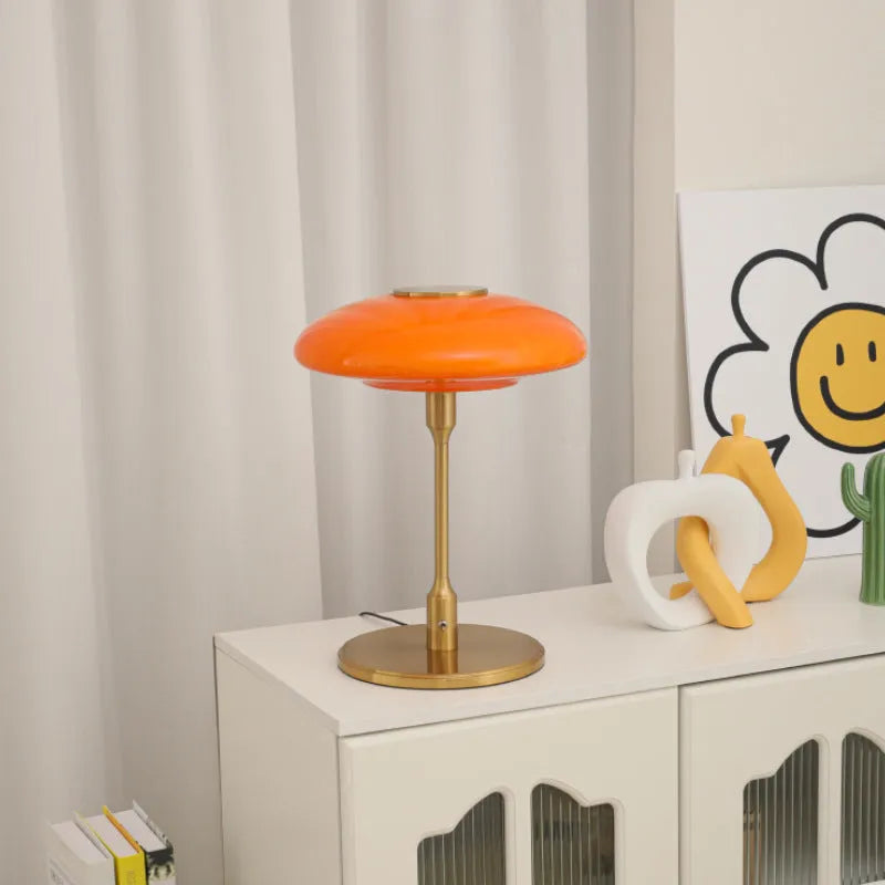 Korean style golden orange atmosphere light with metal base on a bedside table.