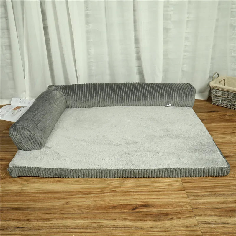 Corduroy dog sofa bed with bolster sides in a grey colour, shown on a wooden floor.