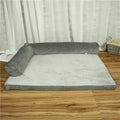 Corduroy dog sofa bed with bolster sides in a grey colour, shown on a wooden floor.
