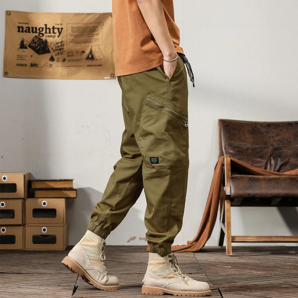 Men's cotton harem pants in khaki with tapered legs and ankle band.