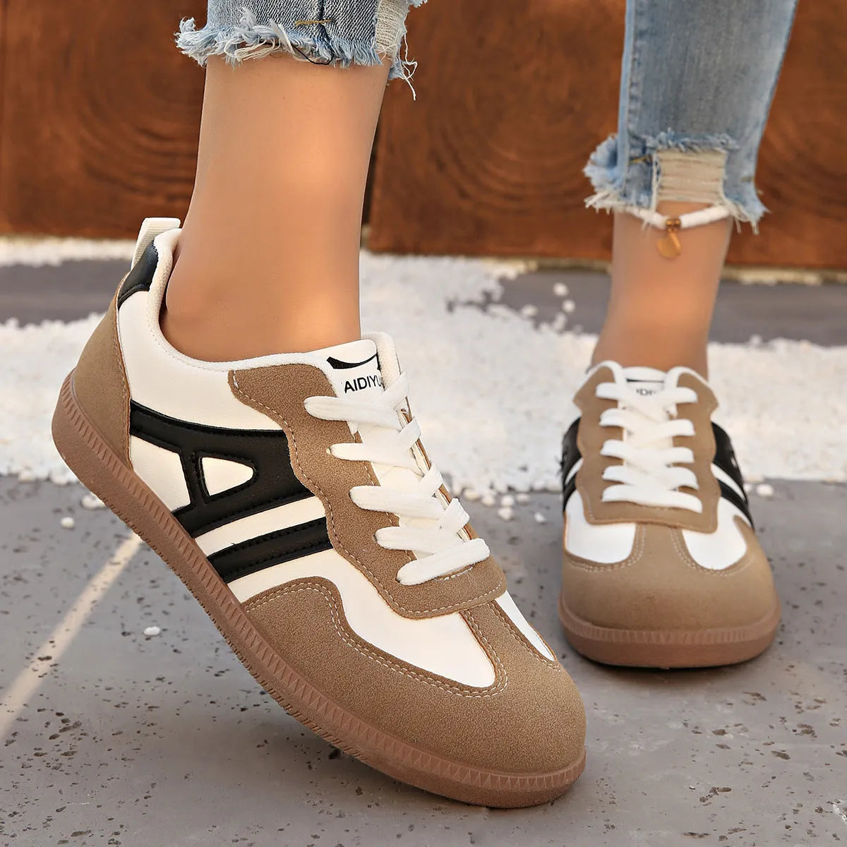 Women's retro style lace-up jogging shoes in grey with a cross strap and low platform heel.