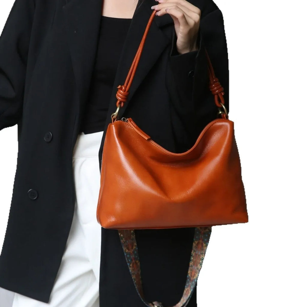 Genuine leather creative large capacity hand and shoulder commuter bag in caramel colour with pillow shape and patchwork details
