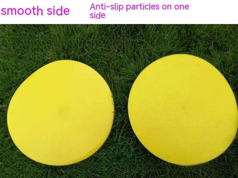 Flat yellow TPE football training landmark pad disc on grass, 23 cm in diameter.