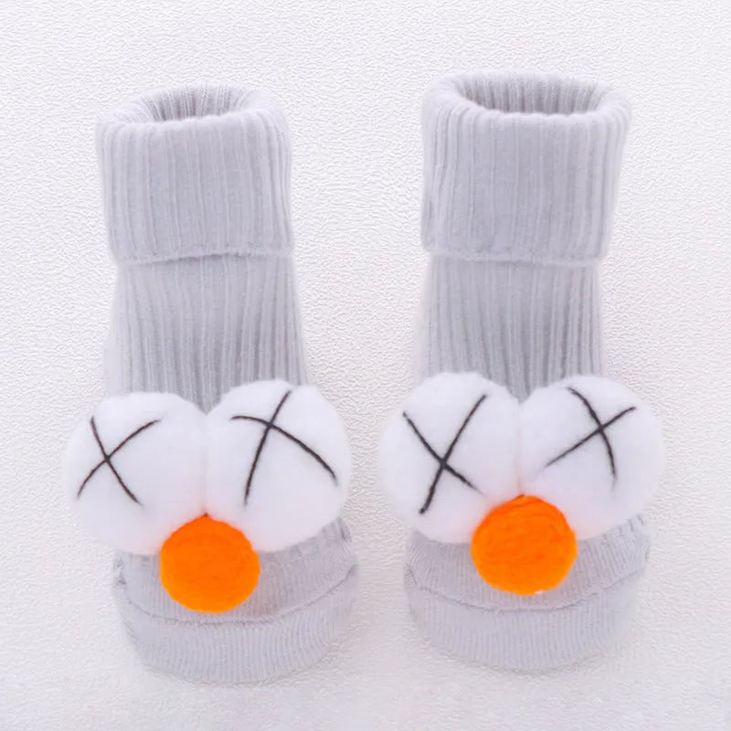 Cotton baby floor socks in various designs including blue bow and lion, showing sizes for infants 0-3 months