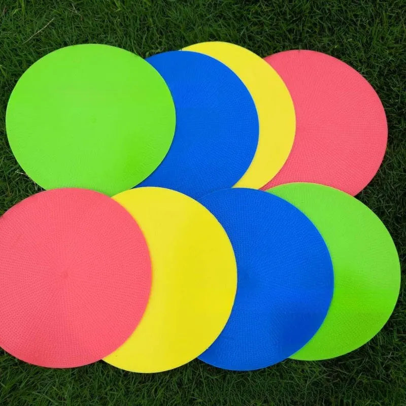 Flat yellow TPE football training landmark pad disc on grass, 23 cm in diameter.