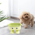 Robot-shaped elevated cat bowl with tilted feeding surface in green colour