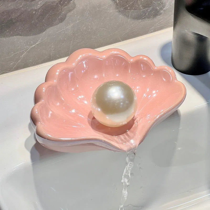 White and pink plastic shell-shaped soap dish for bathroom countertops.