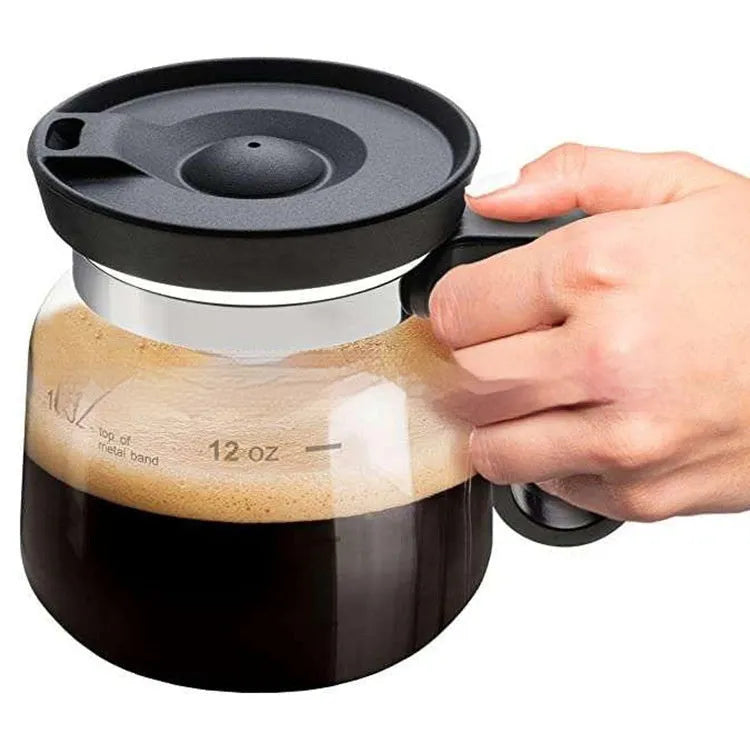 Transparent borosilicate glass coffee maker with a black silicone cover on its lid.