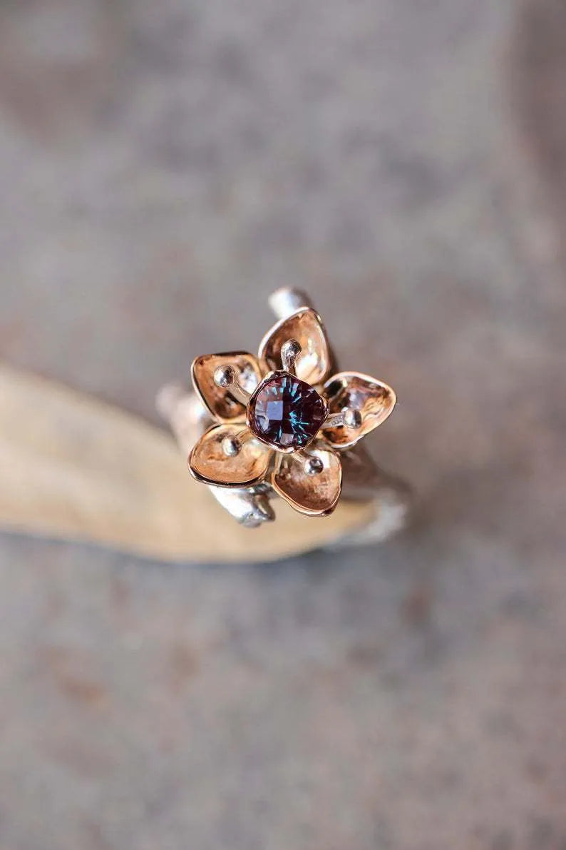 Two-tone silver alloy women's ring with floral geometric design on a flat surface