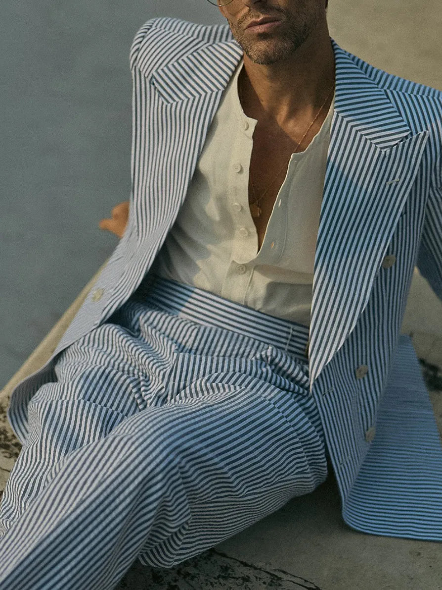 Blue and white striped polyester suit set with blazer and trousers on a hanger.