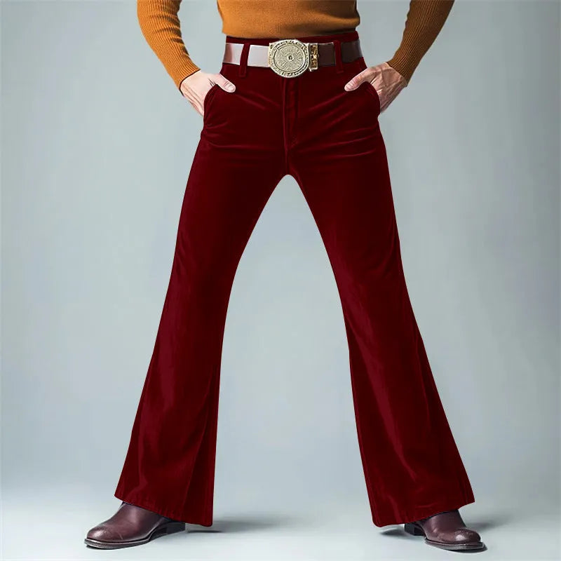 Man wearing gold velvet slim flared suit trousers in dark red for a formal banquet setting.