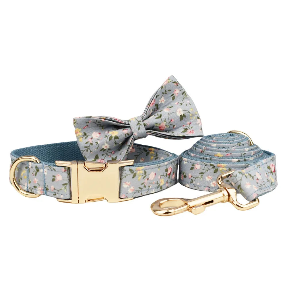 Blue floral pattern dog collar accessories set with adjustable collar, matching leash, bow, vest, and poop bag