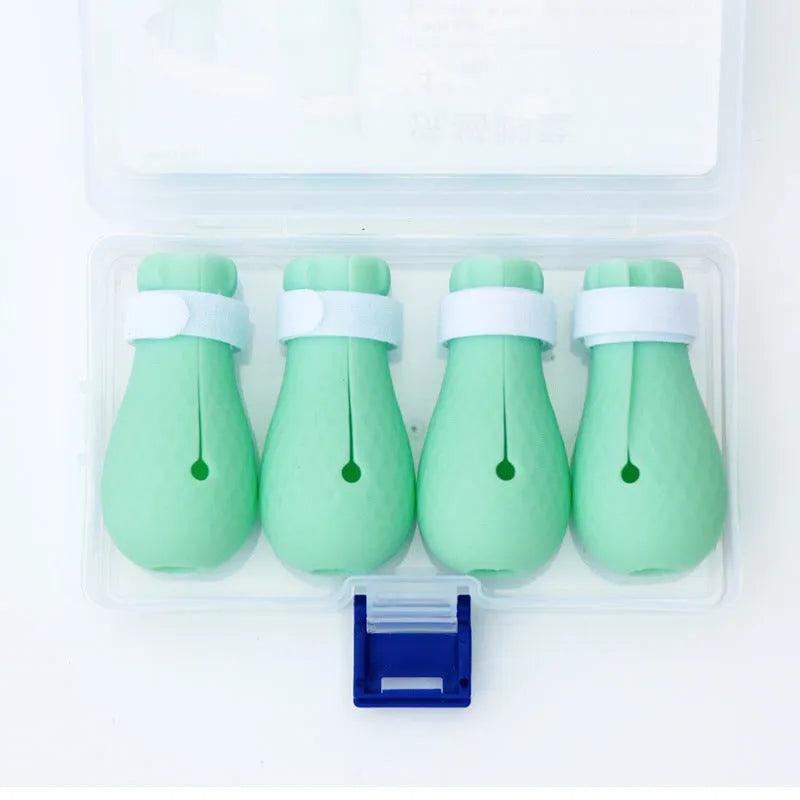 Set of four green silicone cat anti-scratch foot covers or gloves for pet handling.