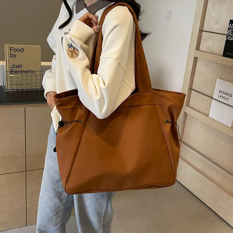 Soft Oxford cloth foldable tote bag shown in one of five colours: black, brown, dark grey, light grey, or purple.