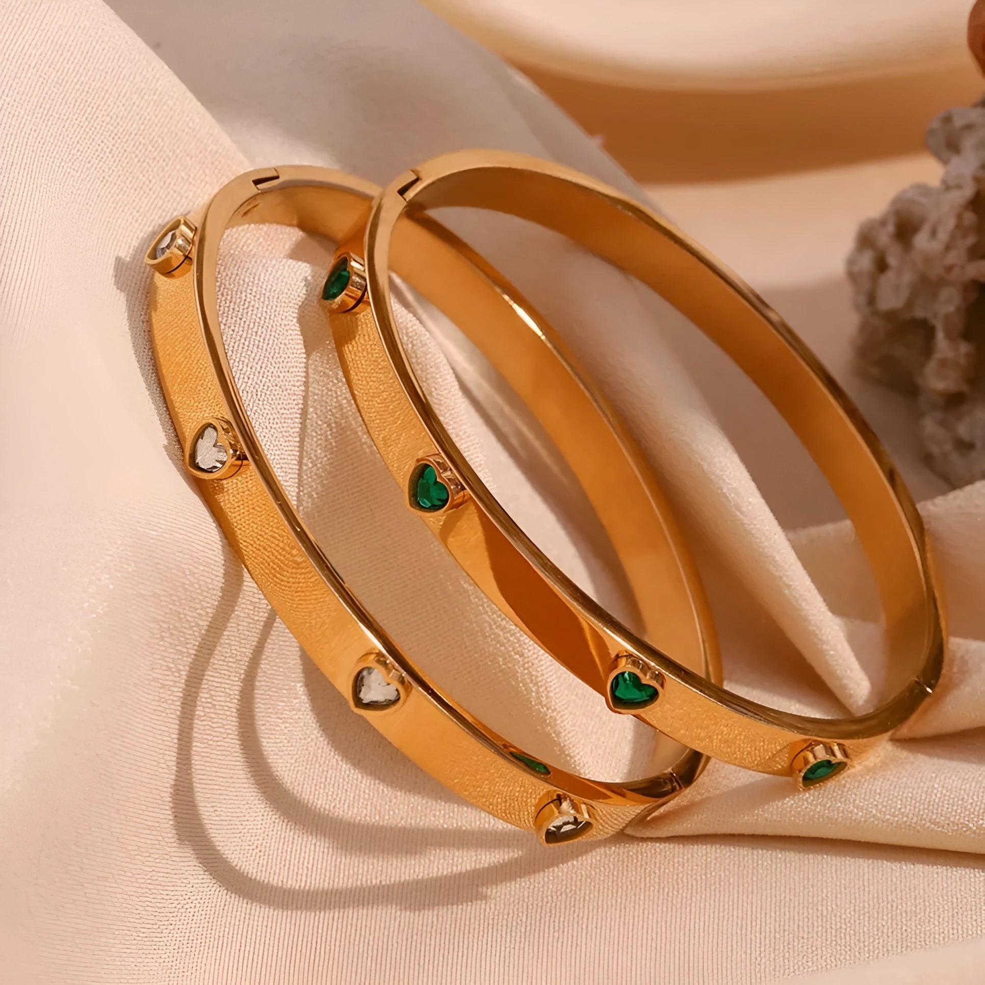A stainless steel bracelet with a small micro-inlaid peach heart charm, shown in a golden electroplated finish.