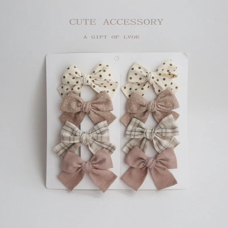 Children's dovetail bow hairclips in eight colour patterns including grid dots and floral designs