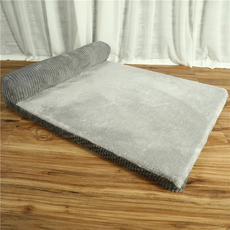 Corduroy dog sofa bed with bolster sides in a grey colour, shown on a wooden floor.