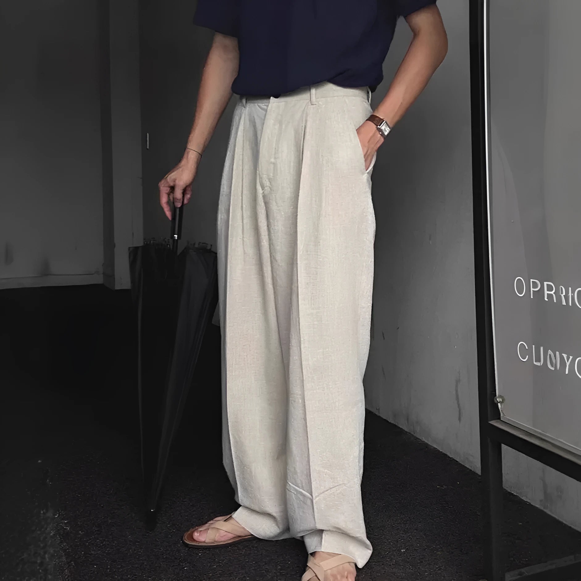 Men's apricot coloured loose-fit cotton linen blend trousers on a hanger, showing zip fly and mid-waist design.