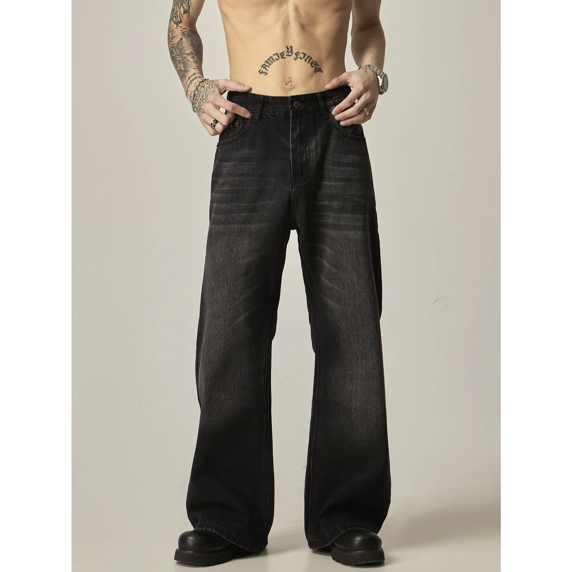 Black loose straight leg retro jeans on a hanger, showing zipper fly detail.