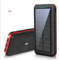 Black portable power bank with Qi wireless charging pad and three USB ports on the side