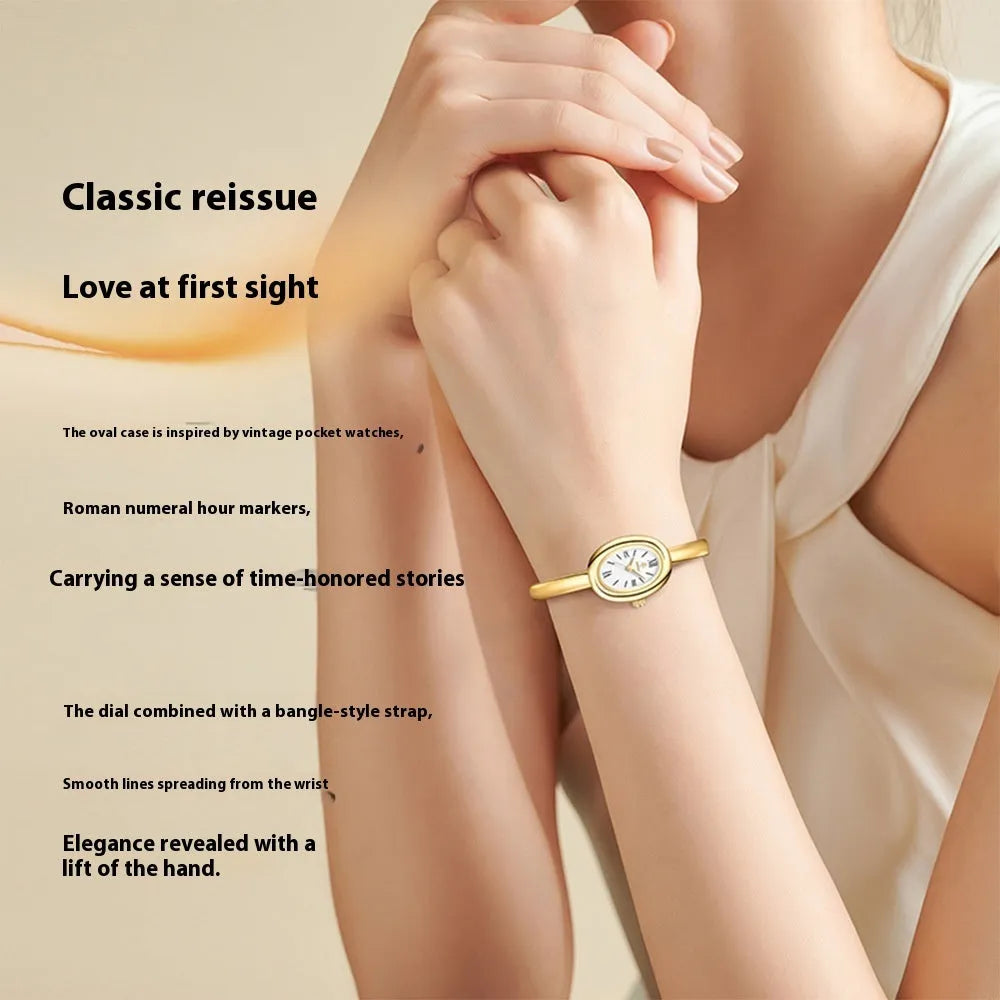 Women's gold and silver oval retro quartz watch with spiral pattern dial on wrist.