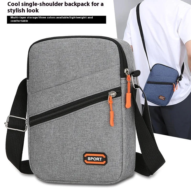Lightweight solid colour oxford cloth crossbody commuter bag in black, navy, or silver grey.
