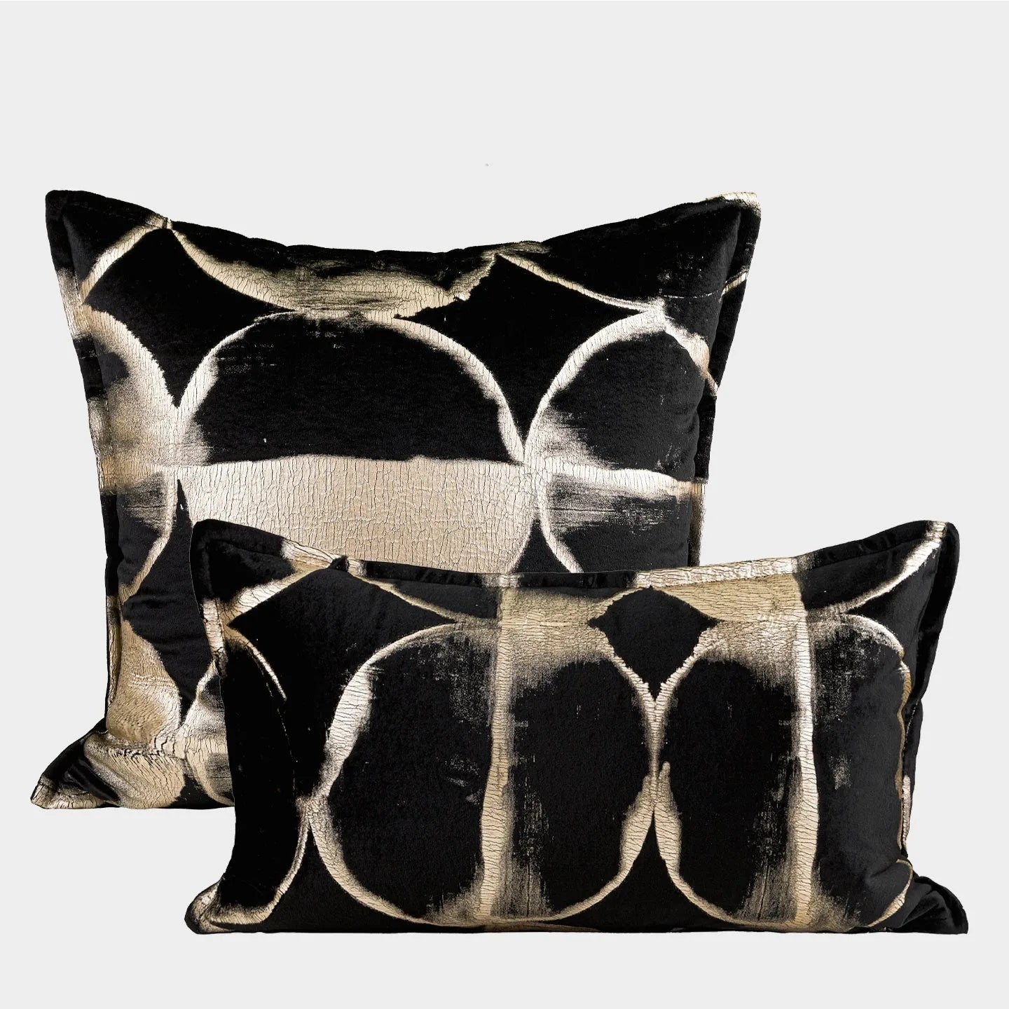 Black and gold abstract patterned square cushion on a grey sofa