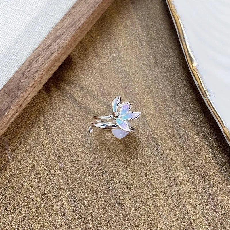 Adjustable copper ring with insect motif and colourful drip-oil finish in hand.