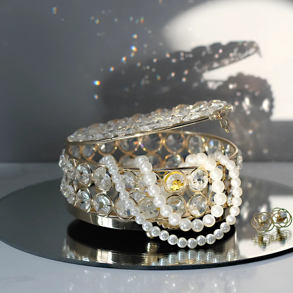 French gold metal jewellery box with a transparent crystal glass lid on a table.