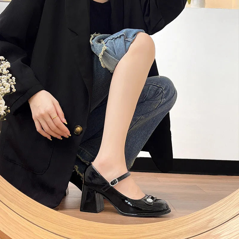 Black patent leather women's chunky heel shoes with round toe and buckle fastening.