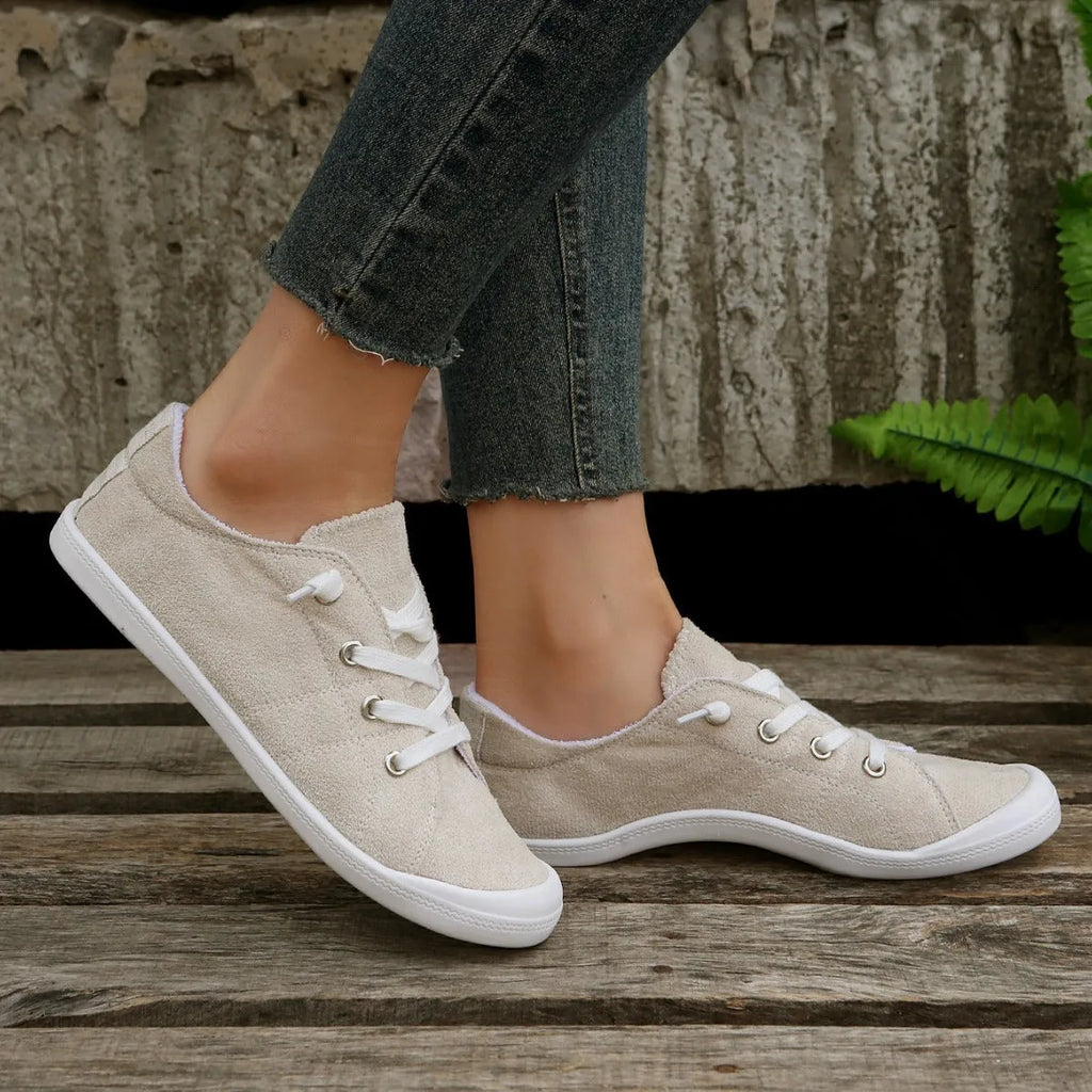 Creamy-white women's low-top fabric casual sneakers with a rubber sole.