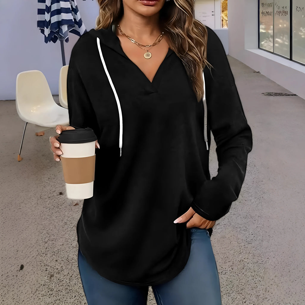 Women's red V-neck sweatshirt with hood showing loose fit and regular-length sleeves