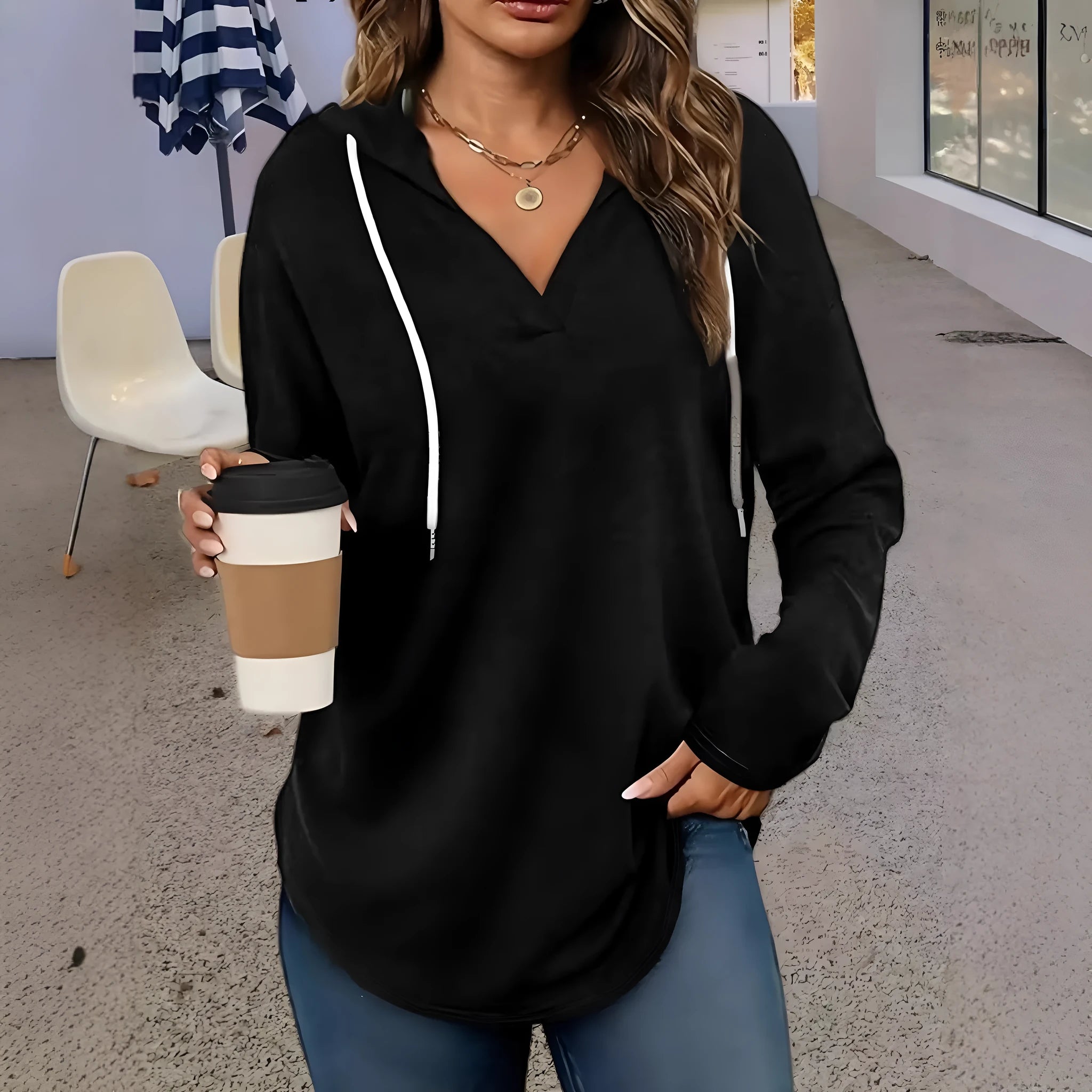 Women's red V-neck sweatshirt with hood showing loose fit and regular-length sleeves
