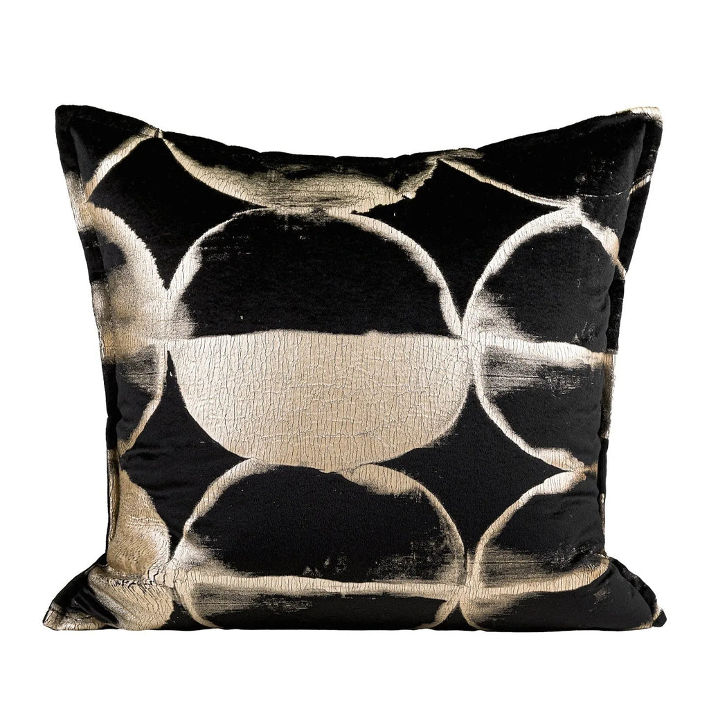 Black and gold abstract patterned square cushion on a grey sofa