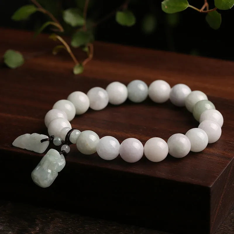 Natural green jade bracelet with a geometric hanging pendant showing choice of symbolic designs.