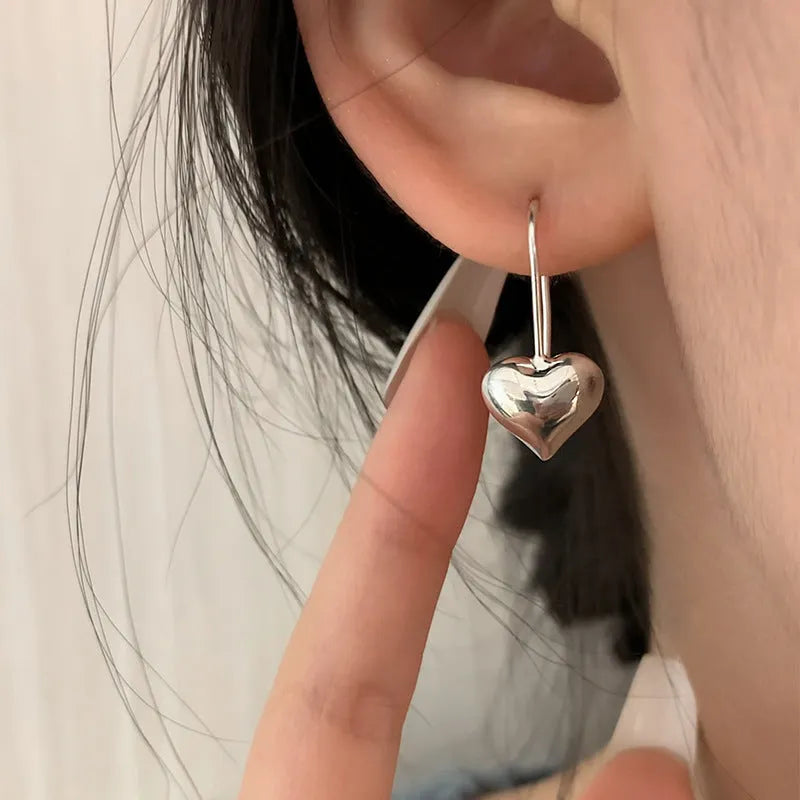 Silver Korean-style three-dimensional heart earrings with glossy finish and ear hook fastening