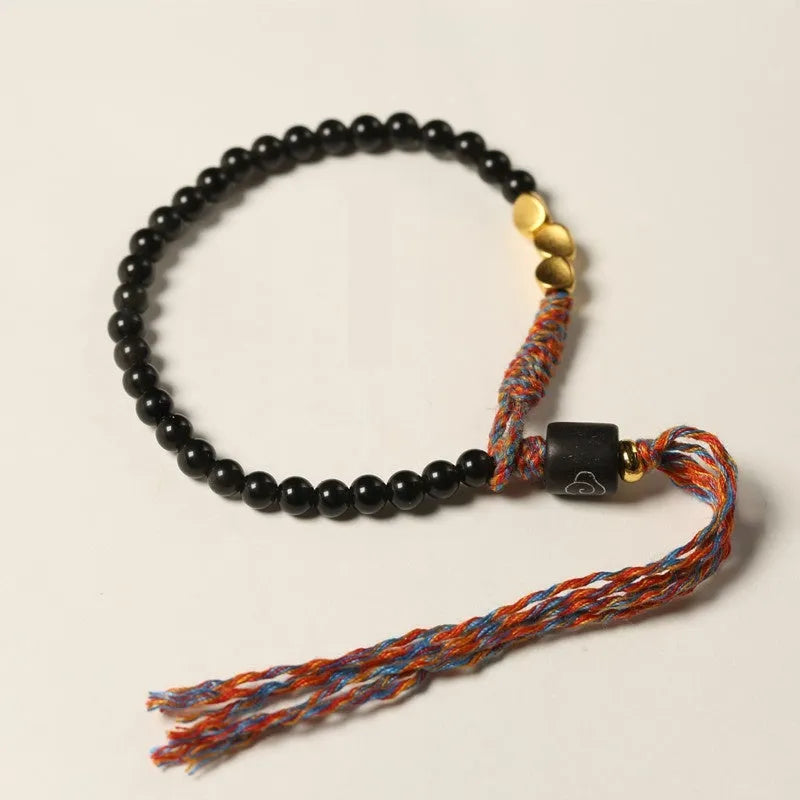 Hand-woven obsidian carrying strap bracelet showing 4mm width and woven texture detail