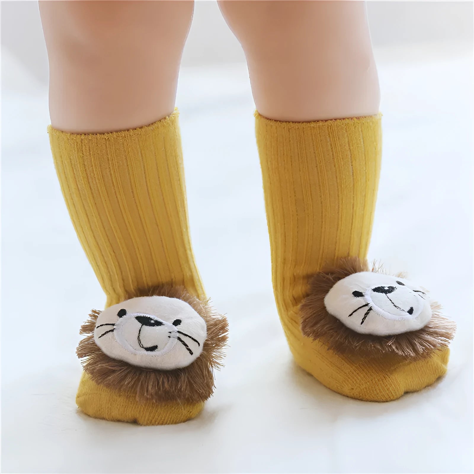Cotton baby floor socks in various designs including blue bow and lion, showing sizes for infants 0-3 months