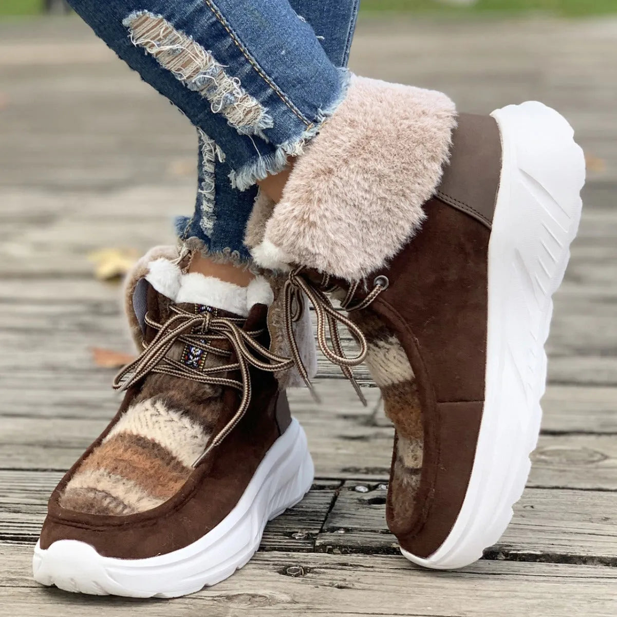 Beige women's lace-up suede snow boots with a thick sole and plush lining on a white background.