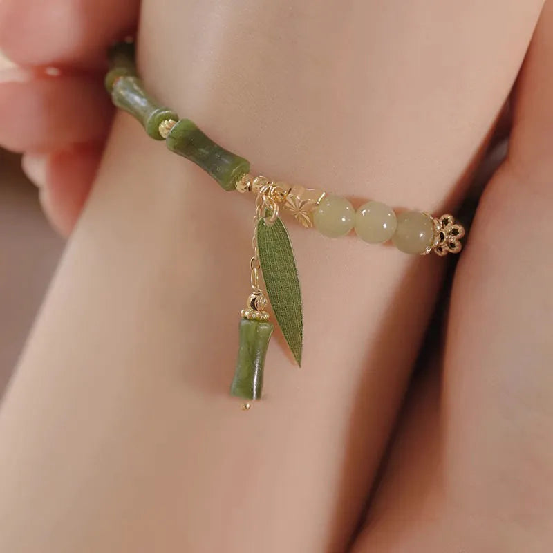 Chinese style handmade glass bead bracelet with bamboo joint elements on a white background.