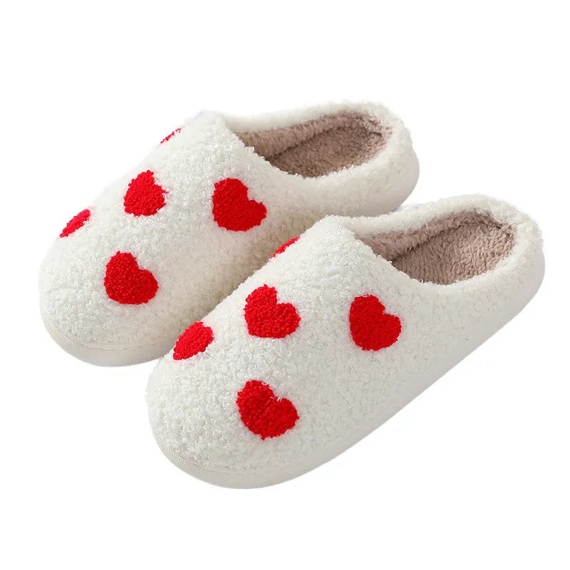Women's plush home slippers in cartoon love style print with round toe and non-slip PVC sole.