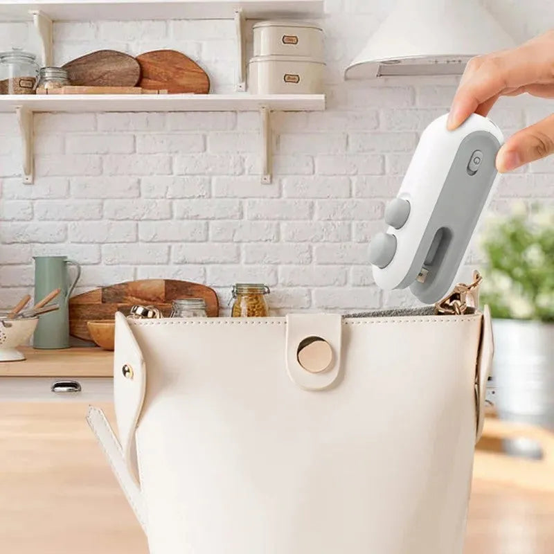 Blue handheld vacuum heat sealer with cutter blade and magnetic backing for food storage