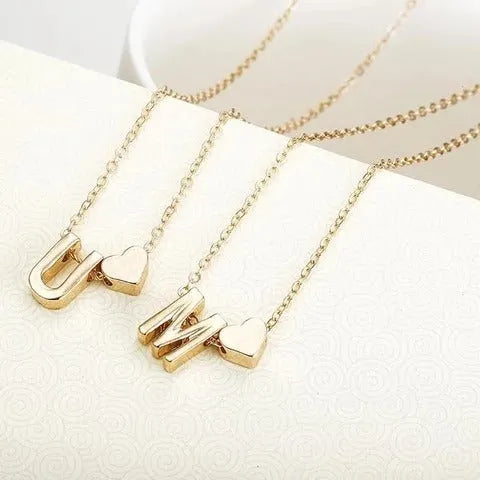 Gold and silver alloy peach heart shaped letter pendant necklace charm on a chain.