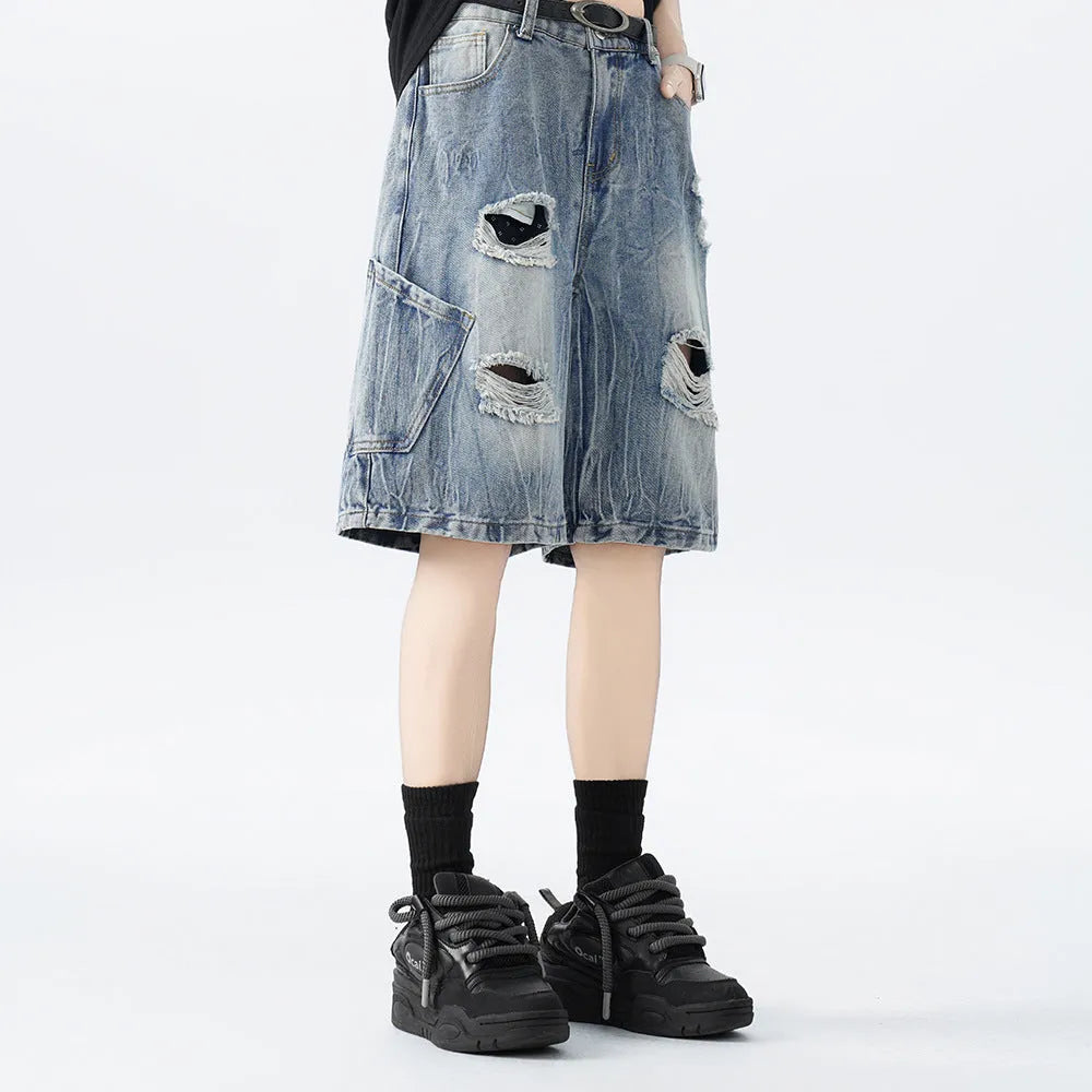 Loose-fit denim shorts with a washed fabric finish and ripped, distressed detailing on the legs.