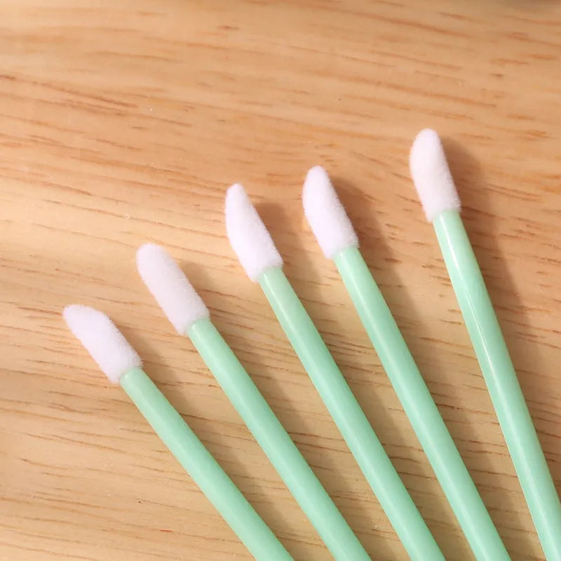 Pack of disposable lip brushes with flocked heads and coloured handles, shown in quantities from 200 to 500 pieces.